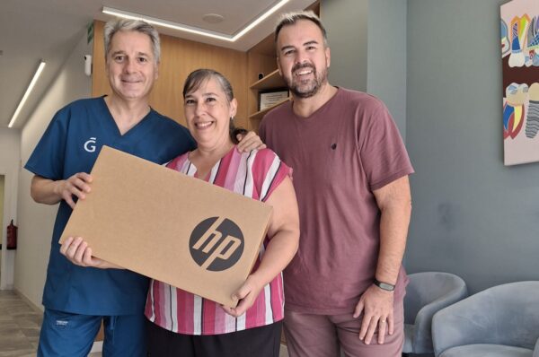 El concejal de Comercio Lucas Jodar entregando uno de los portátiles a una de las ganadoras del sorteo de la campaña La Vuelta al cole